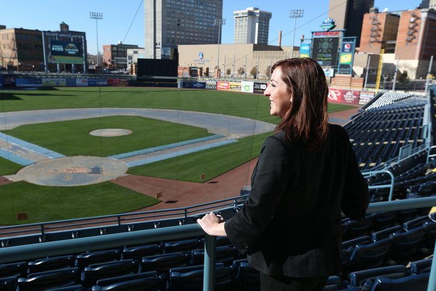 A woman standing at a railing and looking out over the Toledo Mud Hens baseball stadium. 